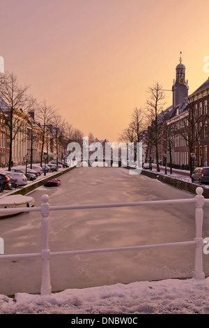 La ville historique de Leiden, Hollande méridionale, Pays-Bas le long d'une rue Rapenburg, et canal de réglage hivernal au coucher du soleil. Banque D'Images