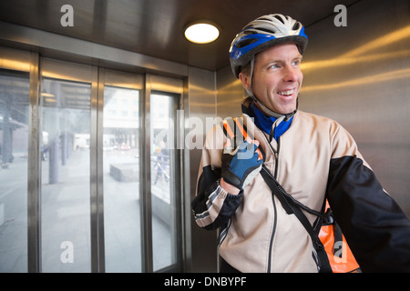 Courier Delivery Man with Backpack dans un ascenseur Banque D'Images