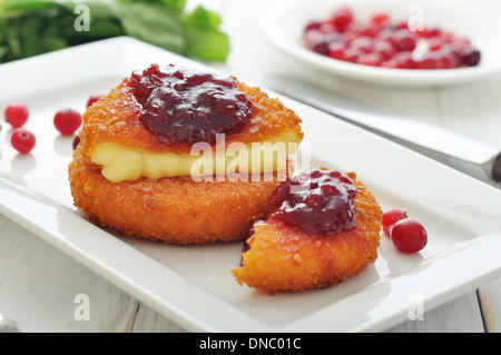 Camembert pané et cuit au four avec sauce aux canneberges sur plaque blanche libre Banque D'Images