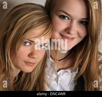 Le portrait de deux soeurs filles scandinaves cute blonde en studio ensemble avec leur siège à proximité les uns des autres Banque D'Images