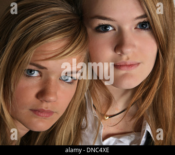 Le portrait de deux soeurs filles scandinaves cute blonde en studio ensemble avec leur siège à proximité les uns des autres Banque D'Images