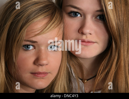 Le portrait de deux soeurs filles scandinaves cute blonde en studio ensemble avec leur siège à proximité les uns des autres Banque D'Images