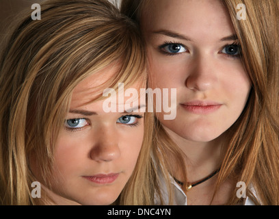 Le portrait de deux soeurs filles scandinaves cute blonde en studio ensemble avec leur siège à proximité les uns des autres Banque D'Images