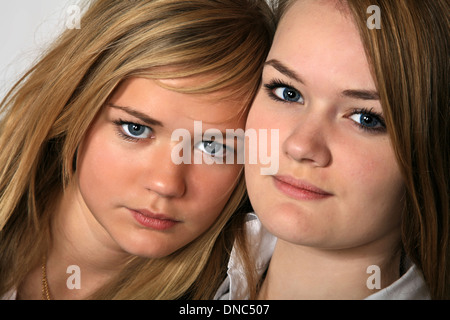 Le portrait de deux soeurs filles scandinaves cute blonde en studio ensemble avec leur siège à proximité les uns des autres Banque D'Images