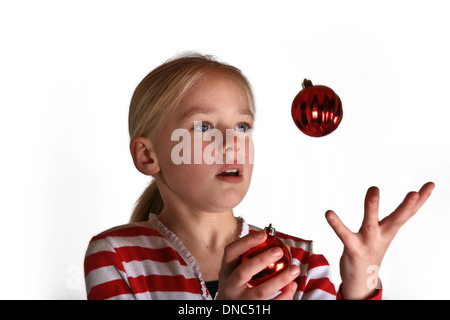 Le Portrait of a cute girl scandinave en studio, à jongler avec une boule de noël Banque D'Images