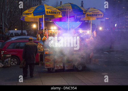 Vendeur de hot-dog fume toute la zone hot dog cuisson près de City Hall Park au crépuscule à Manhattan, New York. Banque D'Images