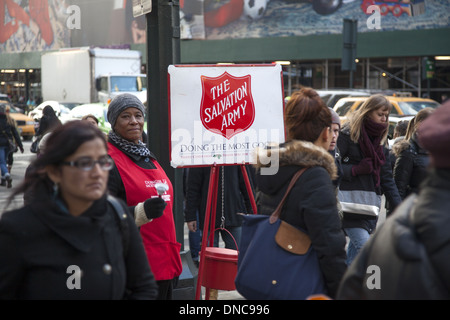 Femme bénévole recueille des fonds pour l'Armée du Salut pendant la saison de Noël à 34th Street et Broadway, New York. Banque D'Images