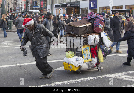 Sans-abri dans l'esprit de Noël de luttes Broadway avec ses biens dans la TOE. Banque D'Images