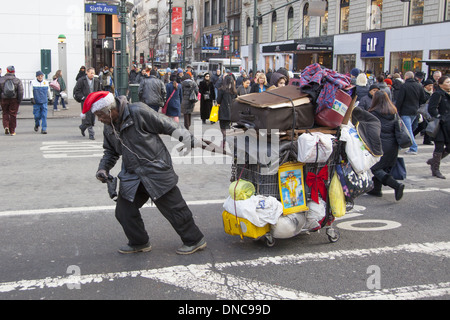 Sans-abri dans l'esprit de Noël de luttes Broadway avec ses biens dans la TOE. Banque D'Images