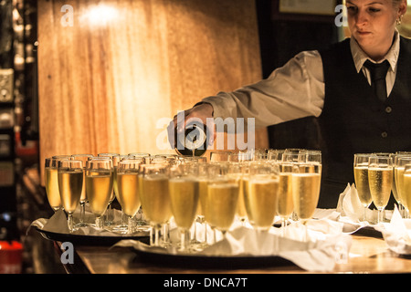 Serveuse verse du Champagne à une réception de mariage Banque D'Images