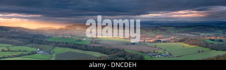 Les derniers rayons de lumière à travers la campagne Herefordshire dart secondes avant l'hiver soleil est obscurci par de gros nuages. Banque D'Images