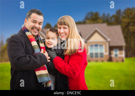 Happy Mixed Race jeune famille en face de belle maison. Banque D'Images