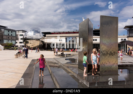 Enfants jouant dans les fontaines de la place du millénaire par une chaude journée d'été, Bristol, UK Banque D'Images