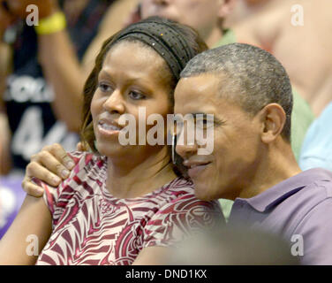 Manoa Stan Sheriff Center, USA. Dec 22, 2013. Le président des États-Unis Barack Obama donne à la Première Dame Michelle Obama une accolade comme elles et leurs filles Malia et Sasha Obama Obama assister à la Hawaiian Airlines Diamond Head Classic men's basketball match entre l'Oregon State Beavers et l'Université d'Akron Zips à l'Université de Hawaï à Manoa Stan Sheriff Center, USA, 22 décembre 2013. Le frère de la première dame, Craig Robinson, est l'Oregon State University Men's Head Coach de basket-ball. Credit : Cory Lum / Piscine via CNP/dpa/Alamy Live News Banque D'Images