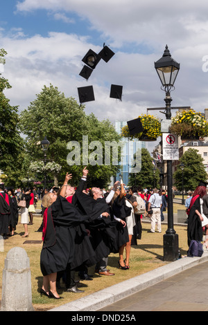 Graduates throwing mortarboards leur après la cérémonie. Cérémonie de remise des diplômes à l'UWE College Green, Bristol, Royaume-Uni Banque D'Images
