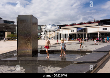 Enfants jouant dans les fontaines de la place du millénaire par une chaude journée d'été, Bristol, UK Banque D'Images