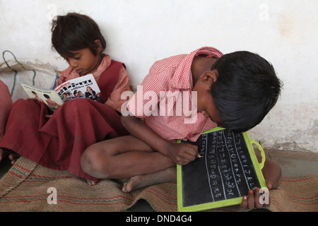 Les étudiants qui étudient à l'école de l'Ashram écrit à la craie sur l'ardoise, le Rangapura Zabua, district, le Madhya Pradesh Banque D'Images