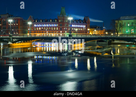 Vue de nuit de l'hiver et Vasabron Riddarholmen, vu de Strömgatan, Stockholm. La fonte des plaques de glace s'écouler à l'avant-plan. Banque D'Images