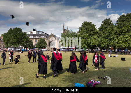 Graduates throwing mortarboards leur après la cérémonie. Cérémonie de remise des diplômes à l'UWE College Green, Bristol, Royaume-Uni Banque D'Images