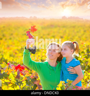 Mère et fille famille sur vignoble automne happy smiling holding grappe Banque D'Images