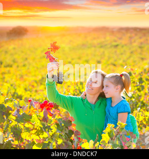 Mère et fille famille sur vignoble automne happy smiling holding grappe Banque D'Images