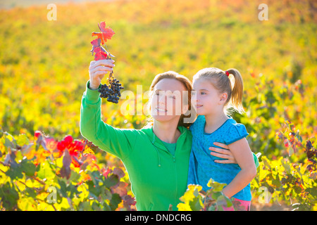 Mère et fille famille sur vignoble automne happy smiling holding grappe Banque D'Images