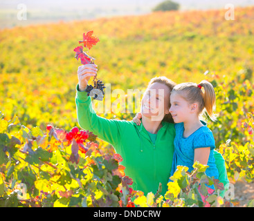 Mère et fille famille sur vignoble automne happy smiling holding grappe Banque D'Images