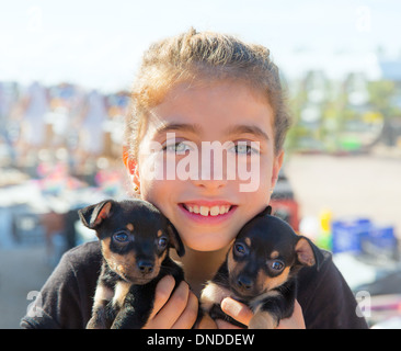 Jeune fille jouant avec les chiens chiot souriant aux yeux bleus Banque D'Images