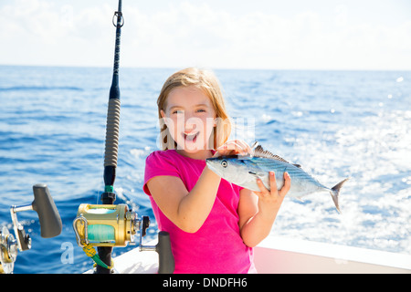 Kid girl blonde Bonito Thon pêche poissons sarda heureux avec des prises à la traîne sur pont de bateau Banque D'Images