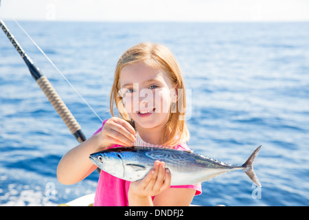 Kid girl blonde Thon pêche au thon à la traîne peu heureux avec capture sur pont de bateau Banque D'Images