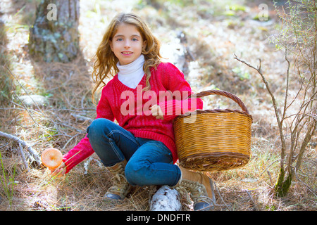 Recherche fille enfant chanterelles champignons avec panier en forêt d'automne Banque D'Images