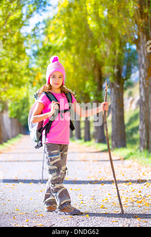 Randonnées kid girl avec bâton de marche et sac à dos explorer la voie de l'automne et pantalon camouflage Banque D'Images