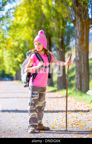 Randonnées kid girl avec bâton de marche et sac à dos explorer la voie de l'automne et pantalon camouflage Banque D'Images