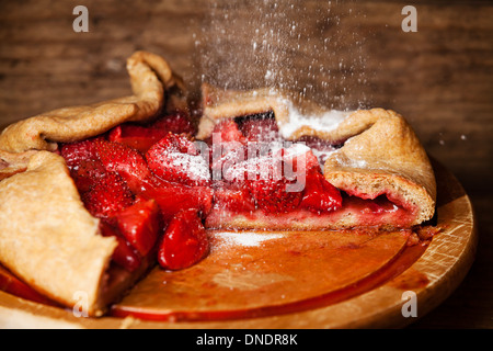 Tarte aux fraises et du sucre en poudre sur fond de bois Banque D'Images