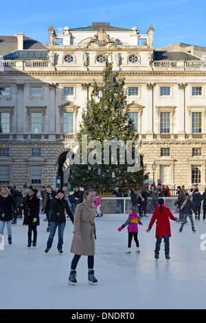 Cour historique de Somerset House avec décorations d'arbres de Noël et personnes appréciant l'arène de patinage sur glace extérieure au Strand London Angleterre Banque D'Images