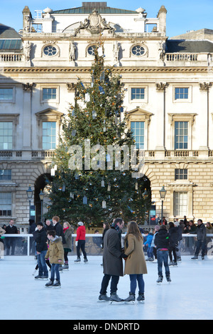 Cour historique de Somerset House avec décorations d'arbres de Noël et personnes appréciant l'arène de patinage sur glace extérieure au Strand London Angleterre Banque D'Images