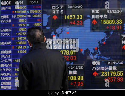 Tokyo, Japon. Le 24 décembre, 2013. Un homme regarde un panneau électronique montrant partager index dans Tokyo, Japon, le 24 décembre 2013. La question de 225 Nikkei Stock Average fini de 18,91 points, de plus que vendredi dernier, à 15 889,33, étendant sa strie de gain à un cinquième jour de marché. Credit : Stringer/Xinhua/Alamy Live News Banque D'Images