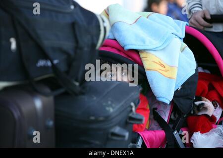 Gaza, Territoires palestiniens. Le 24 décembre, 2013. Une fille palestinienne attend avec sa famille à l'la frontière de Rafah entre l'Egypte et le sud de la bande de Gaza le 24 décembre 2013. Les autorités égyptiennes ont partiellement ouvert de passage de Rafah, la fenêtre principale de Gaza sur le monde, pendant trois jours pour les cas humanitaires et les étudiants en détresse, les autorités frontalières dit.Photo : Moemen Faiz/NurPhoto : Crédit Moemen Faiz/NurPhoto ZUMAPRESS.com/Alamy/Live News Banque D'Images