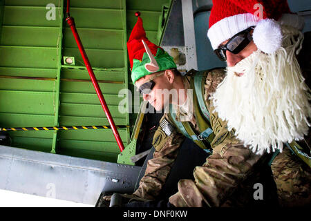 Opération spéciale de l'armée américaine soldats vêtus de costumes de Noël regarder la campagne en Afghanistan à partir de la queue d'un aéronef après la livraison des colis contenant des faisceaux, des bas de Noël et le courrier aux soldats stationnés à une base distante, le 24 décembre 2013 dans la province de Parwan, à l'Afghanistan. Banque D'Images