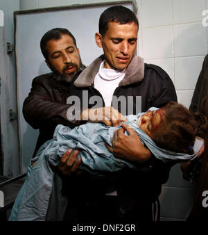 Gaza, Territoires palestiniens. Le 24 décembre, 2013. Un Palestinien par rapport porte le corps sans vie de 3 ans Abu Hala, qui Sebakha medecins dit a été tué par l'obus lors d'une frappe aérienne israélienne sur Al Maghazi, installation à la morgue de l'hôpital d'Al-Aqsa à Deir el Balah, centre de la bande de Gaza, mardi, le 24 décembre 2013. L'air et les forces terrestres israéliennes ont lancé une série d'attaques mardi sur objectifs à la bande de Gaza, tuant une fillette et blessant 10 en réponse à la fusillade mortelle d'un civil israélien par un tireur palestinien. Credit : ZUMA Press, Inc./Alamy Live News Banque D'Images