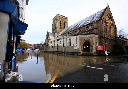 Guildford, Surrey, UK 24 décembre 2013. Un homme se tient sur les sacs de sable, l'arpentage crue des eaux de la rivière Wey à St Nicolas Eglise en Millmead causées par de fortes précipitations au cours des dernières 24 heures. Credit : Bruce McGowan/Alamy Live News Banque D'Images