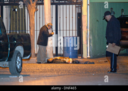 Un enquêteur de police examine le corps d'un homme tué par cartel assassin comme il est allé rendre visite à sa famille le 14 janvier 2009 à Juarez, au Mexique. Le tournage, liée à la drogue en cours à une guerre qui a déjà fait plus de 40 personnes depuis le début de l'année. Plus de 1600 personnes ont été tuées à Juarez en 2008, faisant de la ville la plus violente Juarez au Mexique. Banque D'Images