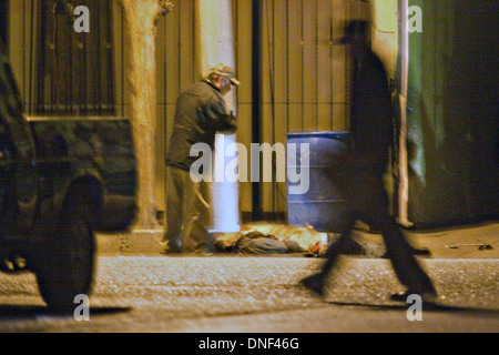 Un enquêteur de police examine le corps d'un homme tué par cartel assassins comme il est allé rendre visite à sa famille le 14 janvier 2009 à Juarez, au Mexique. Le tournage, liée à la drogue en cours à une guerre qui a déjà fait plus de 40 personnes depuis le début de l'année. Plus de 1600 personnes ont été tuées à Juarez en 2008, faisant de la ville la plus violente Juarez au Mexique. Banque D'Images