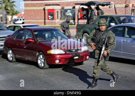 Les soldats de l'armée mexicaine répondre à un assassinat le long d'une route principale quelques instants après tireur armé abattu un ancien officier de police au cours de l'heure de pointe du matin que l'homme mort se trouve derrière le volant dans la voiture rouge le 16 janvier 2009 à Juarez, au Mexique. Le tournage, liée à la drogue en cours à une guerre qui a déjà fait plus de 40 personnes depuis le début de l'année. Plus de 1600 personnes ont été tuées à Juarez en 2008, faisant de la ville la plus violente Juarez au Mexique. Banque D'Images