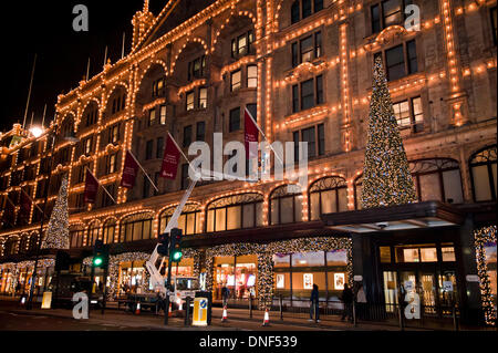 Londres, Royaume-Uni. 24 décembre 2013. Un ouvrier met en place les drapeaux sur le côté du bâtiment. Harrods L'Harrods Vente du Jeudi le 26 décembre 2013. Credit : Pete Maclaine/Alamy Live News Banque D'Images