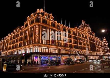 Londres, Royaume-Uni. 24 décembre 2013. Un ouvrier met en place les drapeaux sur le côté du bâtiment Harrods.l a vente Harrods ouvre le jeudi le 26 décembre 2013. Credit : Pete Maclaine/Alamy Live News Banque D'Images