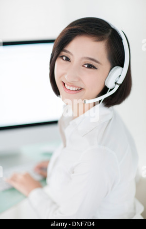 Cheerful businesswoman with headset in office Banque D'Images
