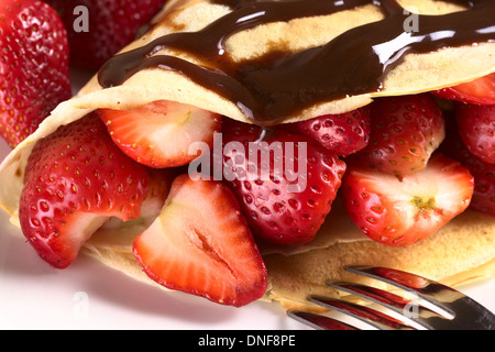 La crêpe remplie de fraises fraîches et sauce au chocolat sur le dessus Banque D'Images