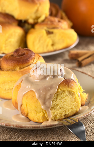 Brioche à la citrouille avec glaçage à la cannelle (Selective Focus, Focus sur le bord avant du rouleau et le glaçage) Banque D'Images