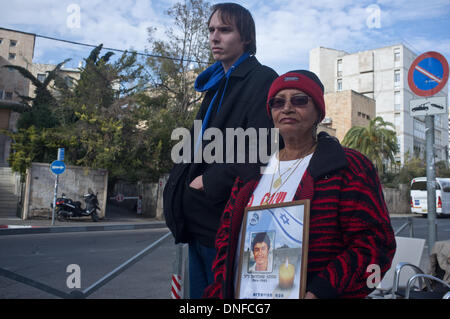 Jérusalem, Israël . Dec 25, 2013. VARDA AKIVA, mère de assassiné Shaltiel Akiva (1964-1985), porte une photo de son fils comme elle proteste à l'extérieur de la résidence du premier ministre contre la libération des prisonniers palestiniens. Jérusalem, Israël. 25-Dec-2013. Israël à libérer les prisonniers palestiniens, parmi eux les meurtriers condamnés avec "du sang sur les mains", dans ce qui est considéré comme une 'troisième impulsion' dans le cadre du processus de négociations de paix. Credit : Alon Nir/Alamy Live News Banque D'Images